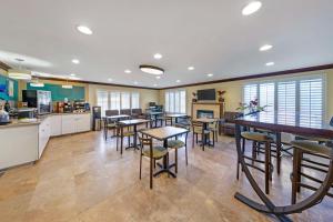 a cafeteria with tables and chairs and a kitchen at Best Western Harbour Inn & Suites Huntington - Sunset Beach in Huntington Beach