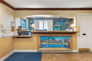 a living room with a fireplace with a painting on it at Best Western Harbour Inn & Suites Huntington - Sunset Beach in Huntington Beach