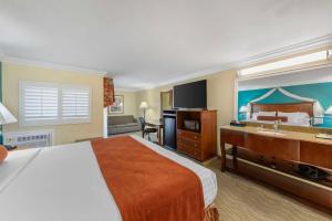 a hotel room with a large bed and a sink at Best Western Harbour Inn & Suites Huntington - Sunset Beach in Huntington Beach