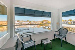 a balcony with two chairs and a view of a marina at Best Western Harbour Inn & Suites Huntington - Sunset Beach in Huntington Beach
