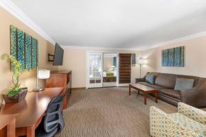 a living room with a couch and a table at Best Western Harbour Inn & Suites Huntington - Sunset Beach in Huntington Beach