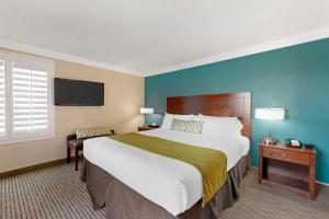 a hotel room with a large bed and a window at Best Western Harbour Inn & Suites Huntington - Sunset Beach in Huntington Beach