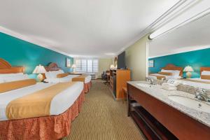 a hotel room with two beds and a sink at Best Western Harbour Inn & Suites Huntington - Sunset Beach in Huntington Beach