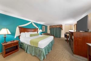 a hotel room with a bed and a television at Best Western Harbour Inn & Suites Huntington - Sunset Beach in Huntington Beach