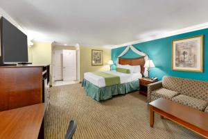 a hotel room with a bed and a couch at Best Western Harbour Inn & Suites Huntington - Sunset Beach in Huntington Beach