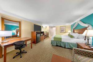 a hotel room with a bed and a desk at Best Western Harbour Inn & Suites Huntington - Sunset Beach in Huntington Beach