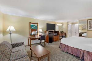a hotel room with a bed and a couch and a desk at Best Western Harbour Inn & Suites Huntington - Sunset Beach in Huntington Beach