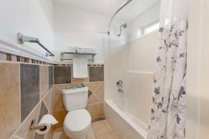a white bathroom with a toilet and a shower at Best Western Harbour Inn & Suites Huntington - Sunset Beach in Huntington Beach