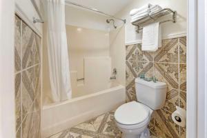 a bathroom with a toilet and a bath tub at Best Western Harbour Inn & Suites Huntington - Sunset Beach in Huntington Beach