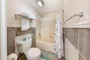 a bathroom with a toilet and a bath tub at Best Western Harbour Inn & Suites Huntington - Sunset Beach in Huntington Beach