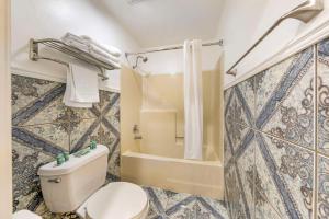 a bathroom with a toilet and a shower at Best Western Harbour Inn & Suites Huntington - Sunset Beach in Huntington Beach