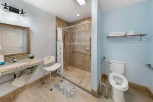a bathroom with a toilet and a sink and a shower at Best Western Harbour Inn & Suites Huntington - Sunset Beach in Huntington Beach