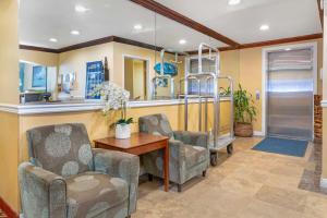 a living room with two chairs and a table at Best Western Harbour Inn & Suites Huntington - Sunset Beach in Huntington Beach