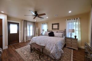 a bedroom with a bed with a cat sitting on it at Gateway Gathering - House in Luckenbach