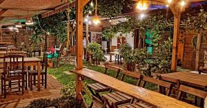 a restaurant with wooden benches and tables and plants at Hostel Vento Leste in Bombinhas
