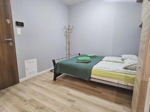 Urban Jungle - Space Apartment في بياويستوك: غرفة نوم مع سرير وأرضية خشبية