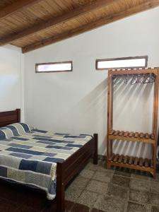 Colonia ChapadmalalDon Pototo Hospedaje Chapadmalal的带一张床和两扇窗户的卧室