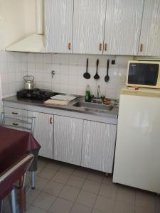 a kitchen with a sink and a refrigerator at Complejo Viejo Sulky in Mina Clavero +52 photos