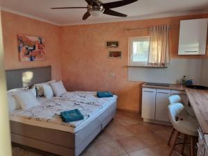 a bedroom with a bed and a table and a kitchen at Casa Maichen Olbia in San Pantaleo