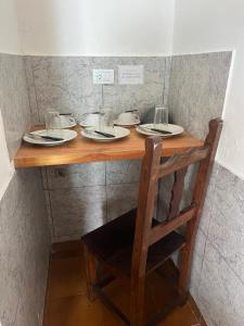 a table with plates and glasses on top of it at Don Pototo Hospedaje Chapadmalal in Colonia Chapadmalal