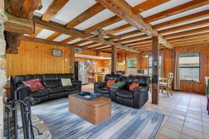 a living room with black leather furniture and a kitchen at River Haven in Fourth Crossing
