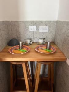 a wooden table with two plates on top of it at Don Pototo Hospedaje Chapadmalal in Colonia Chapadmalal +12 photos
