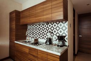 a kitchen with wooden cabinets and a counter top at SOLEMN Cabañas Villaseñor in Tulum