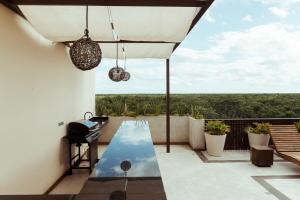a patio with a table and an umbrella and a view at SOLEMN Cabañas Villaseñor in Tulum