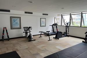 a gym with treadmills and exercise bikes in a room at Flat ao lado do Mar Four Season in Guarujá