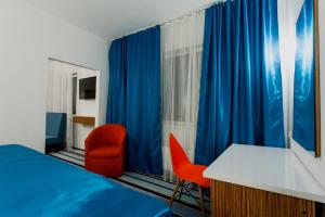 1 dormitorio con cama, escritorio y silla en Global Sky Apartments, en Novosibirsk