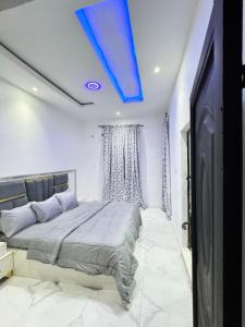 a bedroom with a bed with a blue ceiling at Sunny Service Apartment in Lagos