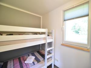 a bedroom with two bunk beds and a window at Insel- Bungalow auf Poel in Insel Poel