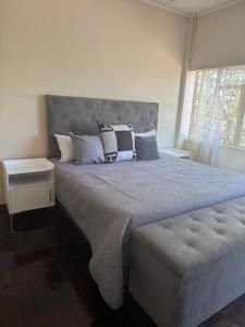 een slaapkamer met een groot bed met kussens erop bij Calenstel in Bulawayo