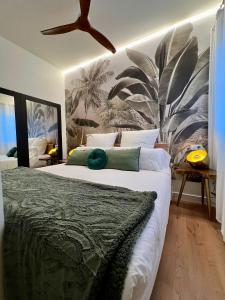 a bedroom with a large bed with a palm tree mural at BILBAO NORTH SHORE APARTMENTs 4 in Bilbao