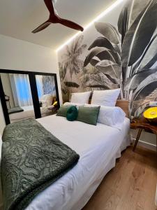 a bedroom with a large white bed with a fan at BILBAO NORTH SHORE APARTMENTs 4 in Bilbao