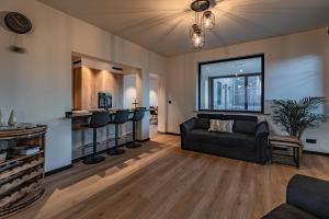 a living room with a couch and a bar at Villa Victoire in Heers