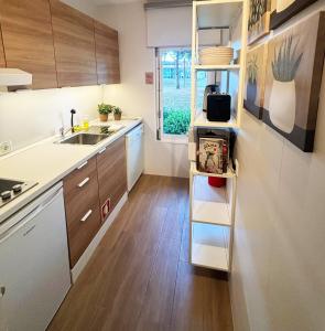 a small kitchen with a sink and a refrigerator at Casa do Zimbro in Troia