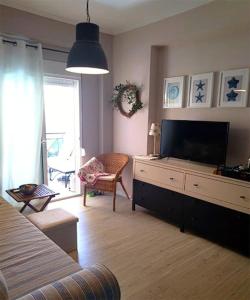 ein Wohnzimmer mit einem Flachbild-TV auf einer Kommode in der Unterkunft Aya Pool Apartment in Kallithea in Kallithea (Chalkidiki) + 17 Fotos