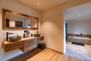 a bathroom with two sinks and a mirror at Villa Victoire in Heers +30 photos