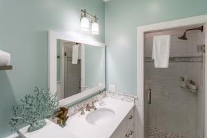 a white bathroom with a sink and a mirror at The Newport Lofts - 611 Thames Street in Newport +6 photos