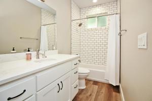 a white bathroom with a sink and a toilet at River Road Retreat in Wimberley +26 photos