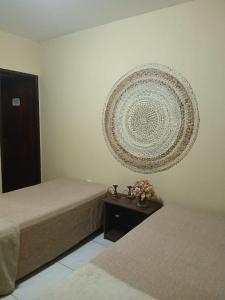a room with two beds and a decoration on the wall at O De Casa in Japaratinga