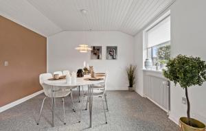 a dining room with a white table and chairs at 2 Bedroom Stunning Home In Grenaa in Grenå