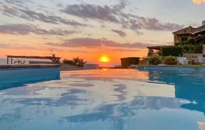 a swimming pool with a sunset in the background at 2 Bedroom Beautiful Home In Diamante in Diamante +16 photos