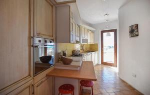 a kitchen with white cabinets and a counter with stools at 2 Bedroom Beautiful Home In Diamante in Diamante