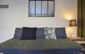 a blue couch with two pillows and a mirror at Gorgeous Home In Esquay-Sur-Seulles in Esquay-sur-Seulles