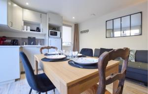 a kitchen and dining room with a wooden table and chairs at Gorgeous Home In Esquay-Sur-Seulles in Esquay-sur-Seulles