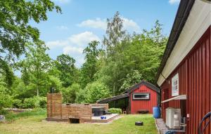 a red barn with a fire pit next to it at 3 Bedroom Amazing Home In Ronneby in Ronneby