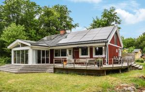 a small red house with a solar roof at 3 Bedroom Amazing Home In Ronneby in Ronneby +17 photos