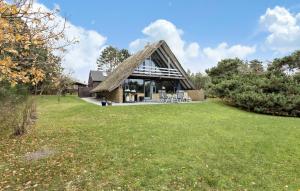 a house with a thatched roof on a field at 3 Bedroom Nice Home In Humble in Humble